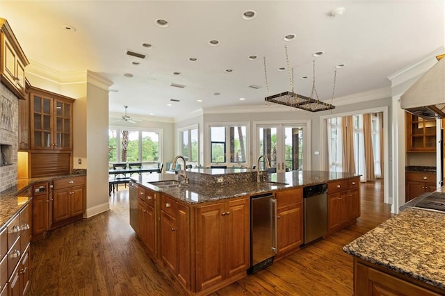 6060 Riverchase Dr S, Mobile, AL 36619 - kitchen with dishwasher, a large island, brown cabinets, dark wood-style floors, and ornamental molding