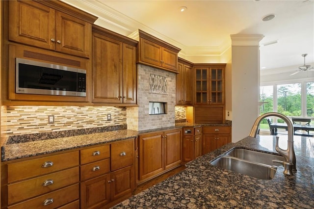 6060 Riverchase Dr S, Mobile, AL 36619 - kitchen with stainless steel microwave, brown cabinets, a ceiling fan, and ornamental molding