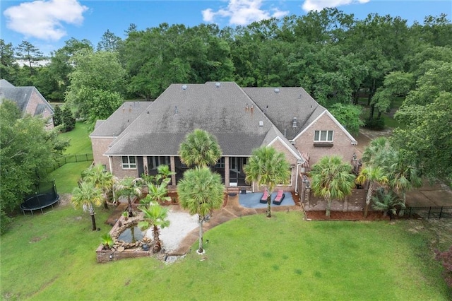 6060 Riverchase Dr S, Mobile, AL 36619 - rear view of house featuring a trampoline, a patio area, and a shingled roof