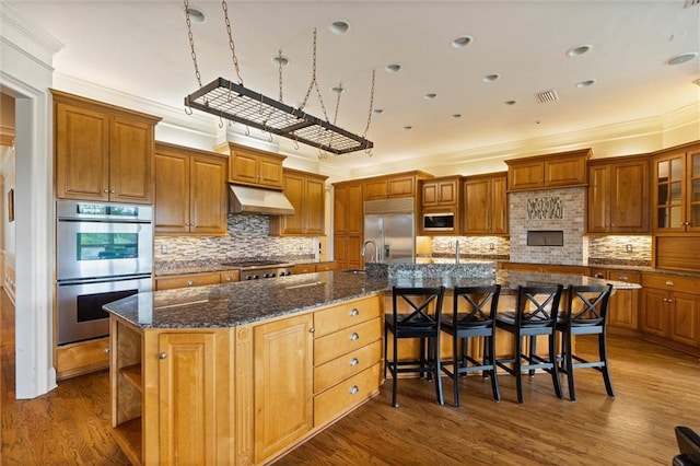 6060 Riverchase Dr S, Mobile, AL 36619 - kitchen with appliances with stainless steel finishes, ventilation hood, a spacious island, ornamental molding, and dark wood-type flooring