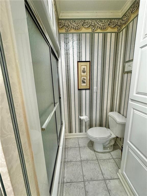 bathroom with tile patterned floors, toilet, and crown molding