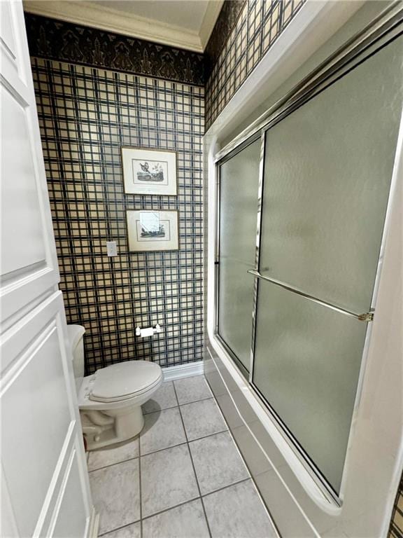 bathroom with tile patterned flooring, toilet, and an enclosed shower