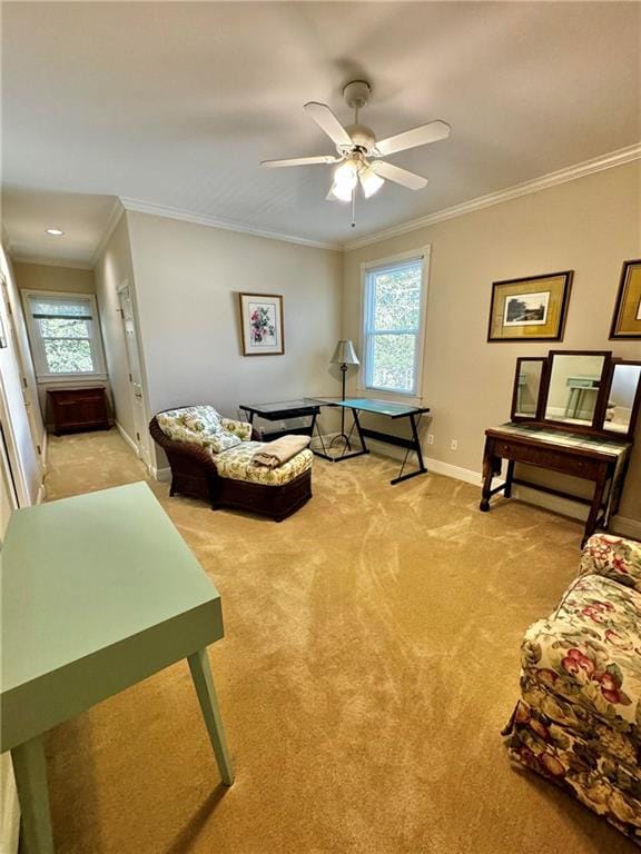 sitting room with carpet, ceiling fan, and ornamental molding