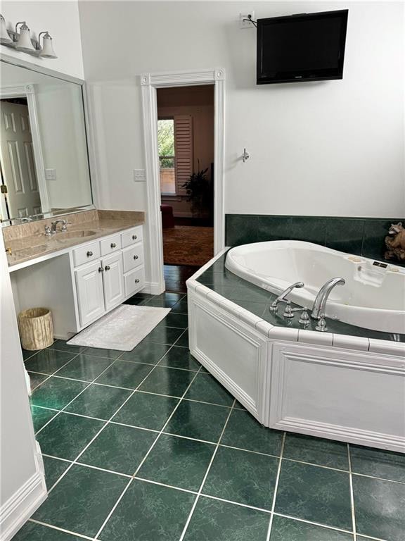 bathroom with tiled tub, tile patterned flooring, and vanity