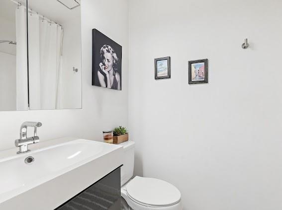 bathroom with large vanity and toilet