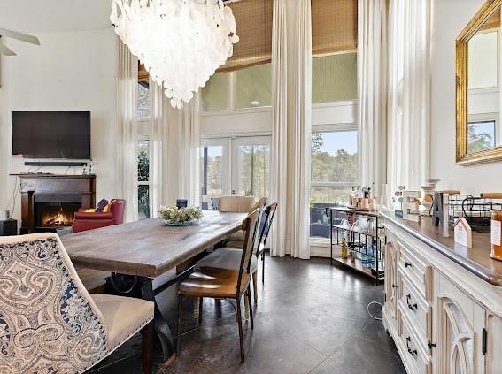 dining room featuring dark tile floors, a chandelier, and french doors