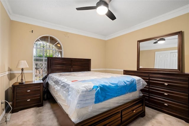 carpeted bedroom featuring ornamental molding and ceiling fan