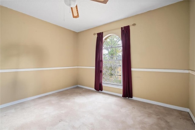 carpeted spare room with ceiling fan