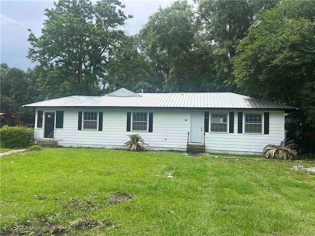 ranch-style house with entry steps, metal roof, and a front lawn