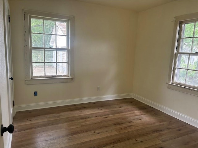 spare room with hardwood / wood-style flooring and baseboards