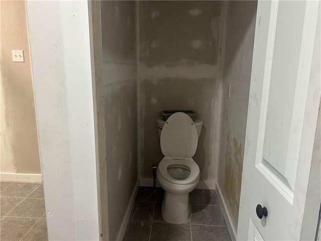 bathroom featuring tile patterned floors, toilet, and baseboards