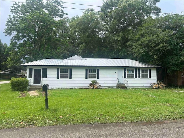 single story home with entry steps, a front lawn, and metal roof