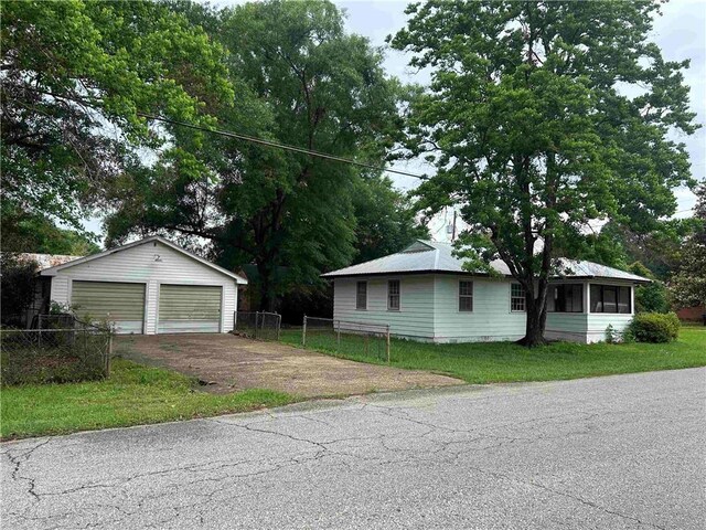 view of front of property with a garage, an outbuilding, and a sunroom