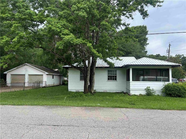 view of front of house with a detached garage, an outdoor structure, and metal roof