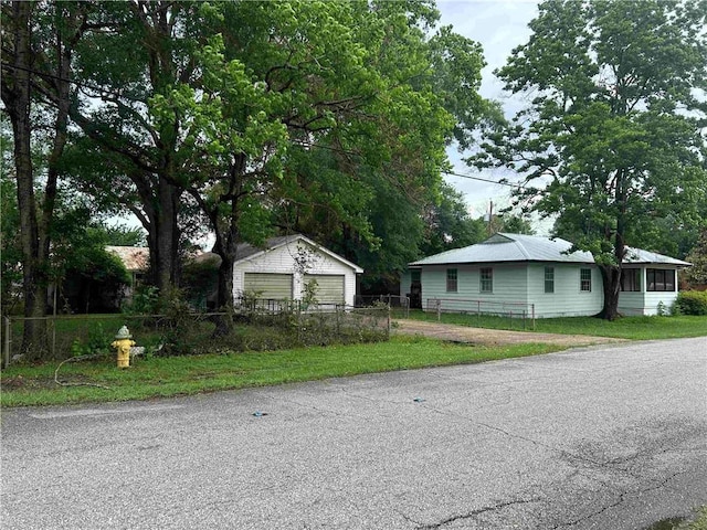 view of front of home with fence, an outdoor structure, and a garage