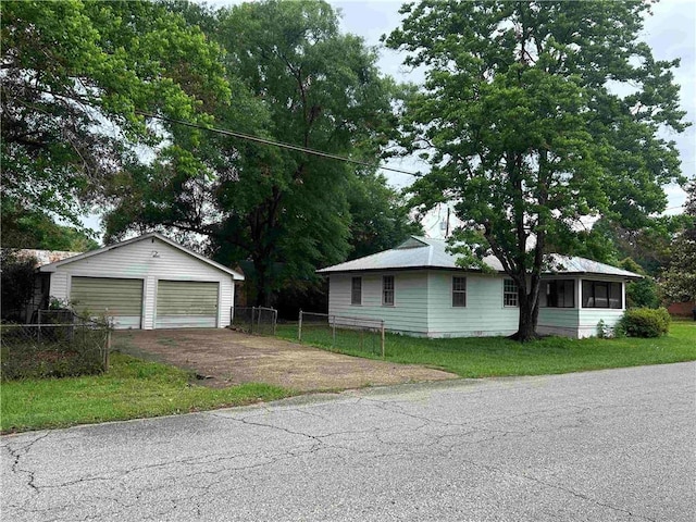 101 8th St, Chickasaw, AL 36611 - view of front of house with a garage, an outbuilding, and a sunroom