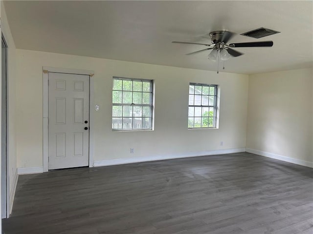 spare room with dark wood-style flooring, ceiling fan, and baseboards