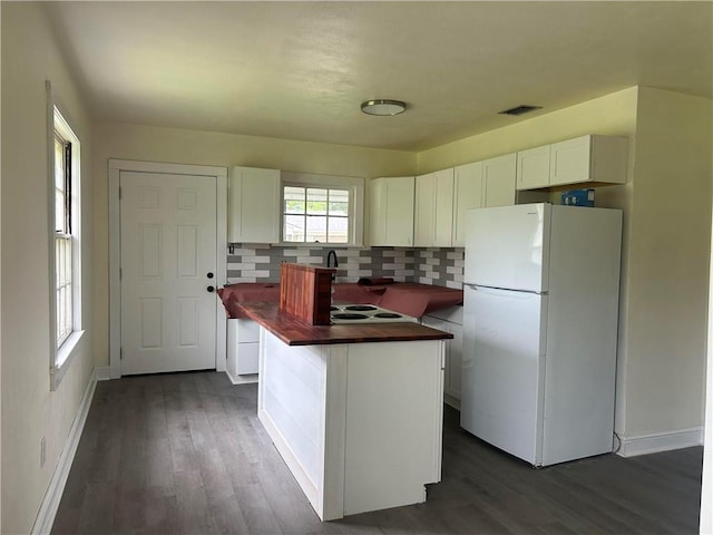 kitchen featuring freestanding refrigerator, wood counters, white cabinetry, and baseboards