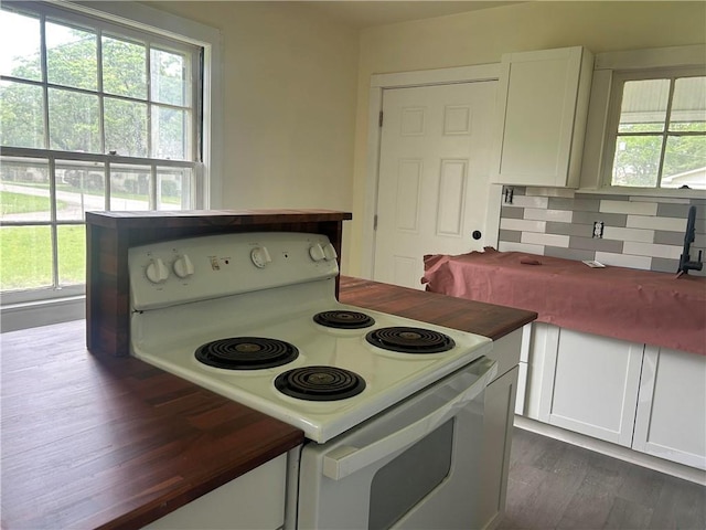 kitchen featuring white electric range oven, healthy amount of natural light, and white cabinets