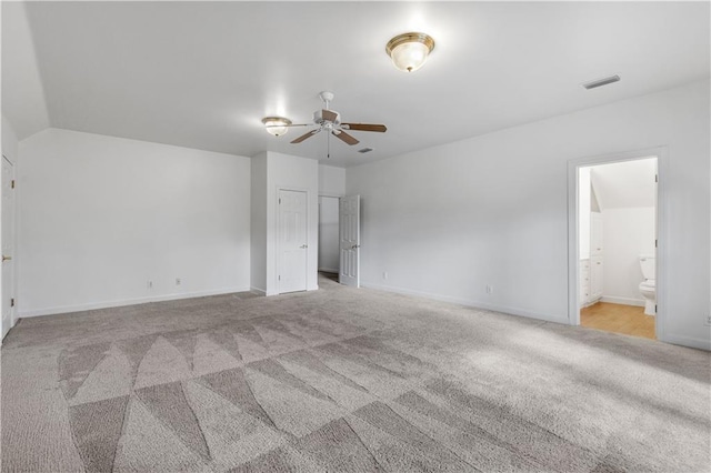 unfurnished bedroom with ensuite bathroom and light colored carpet