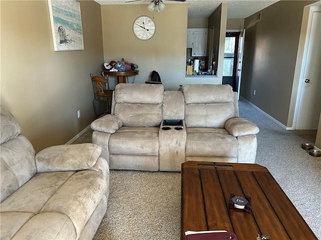 living room featuring light carpet, a textured ceiling, and ceiling fan