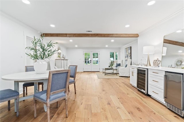 kitchen featuring white cabinetry, crown molding, wine cooler, and light hardwood / wood-style flooring