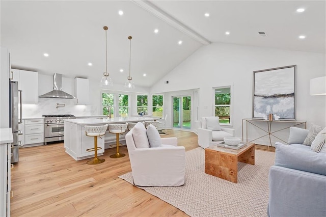 living room featuring beamed ceiling, high vaulted ceiling, and light wood-type flooring