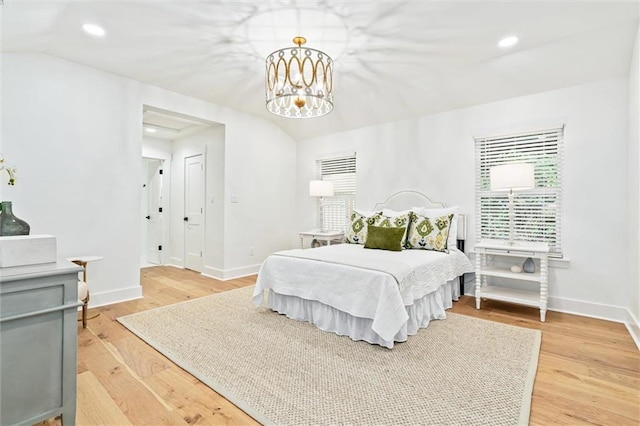 bedroom featuring an inviting chandelier and light hardwood / wood-style flooring