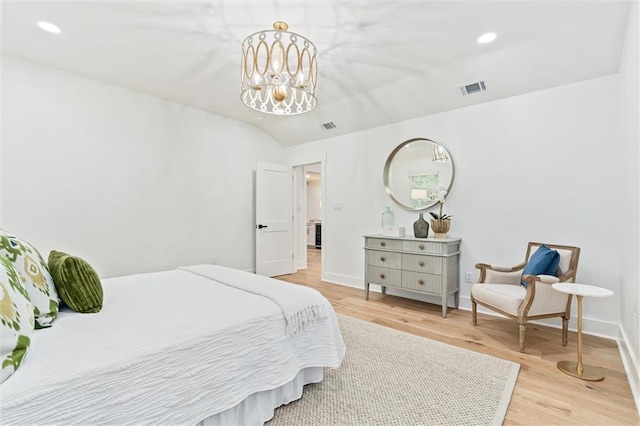 bedroom featuring light hardwood / wood-style flooring, a chandelier, and lofted ceiling