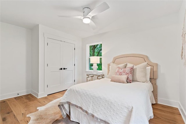 bedroom with ceiling fan, light hardwood / wood-style floors, and a closet