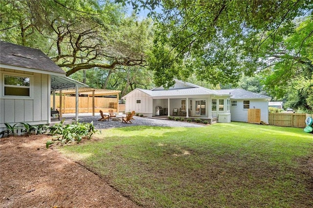 rear view of house featuring a lawn and an outdoor fire pit