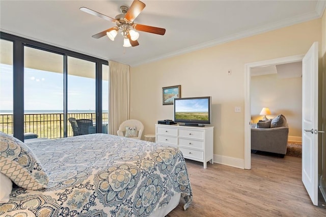 bedroom with access to exterior, a water view, crown molding, and light wood-style flooring