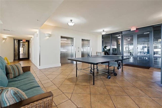 playroom featuring baseboards, elevator, visible vents, and tile patterned floors