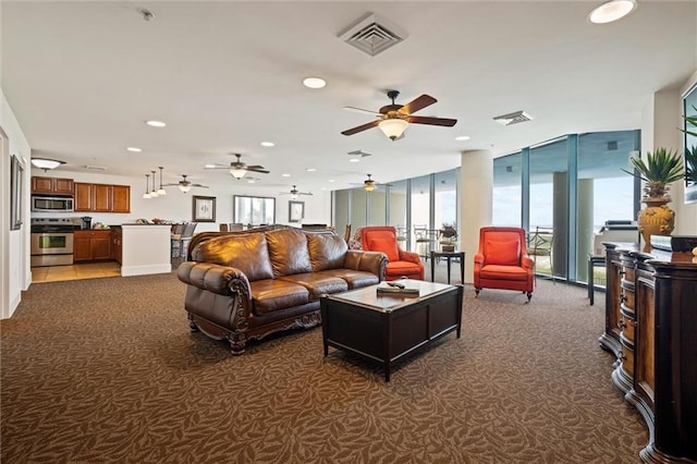 carpeted living area featuring recessed lighting, floor to ceiling windows, and visible vents