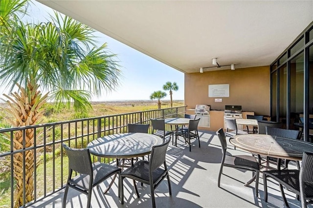 balcony with exterior kitchen and outdoor dining area