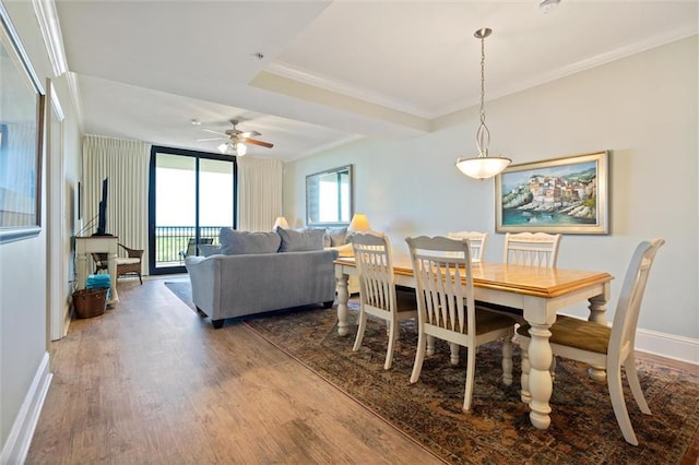 dining area featuring a ceiling fan, baseboards, ornamental molding, and wood finished floors