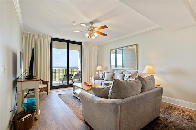 living room with dark wood-style flooring, crown molding, baseboards, and ceiling fan