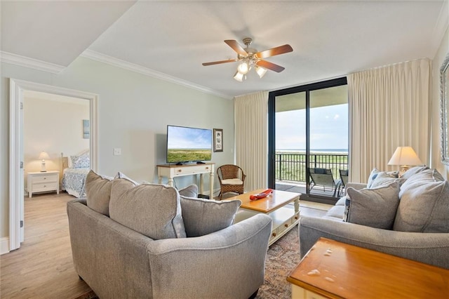 living room featuring ceiling fan, ornamental molding, light wood-type flooring, and floor to ceiling windows