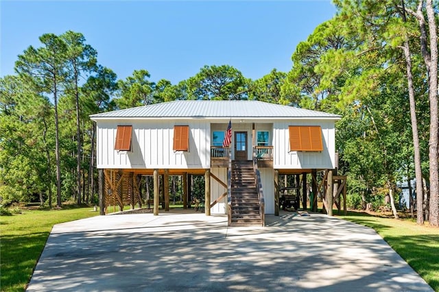 view of front of home with a front lawn, a carport, and covered porch