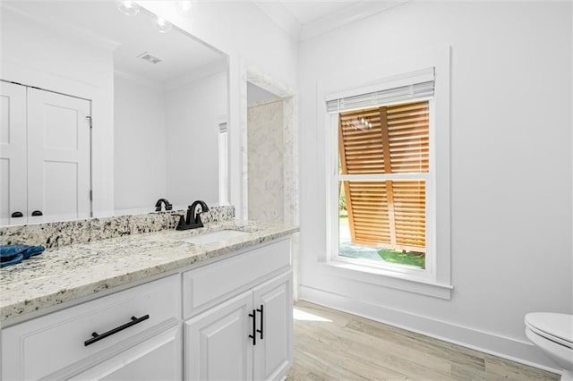 bathroom featuring vanity, crown molding, toilet, and hardwood / wood-style flooring