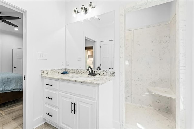 bathroom with ceiling fan, walk in shower, vanity, and wood-type flooring