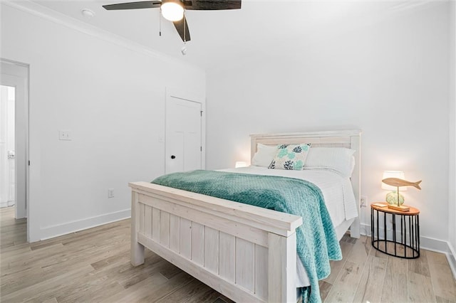 bedroom with crown molding, light hardwood / wood-style flooring, and ceiling fan