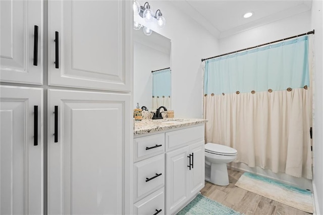 bathroom with vanity, hardwood / wood-style floors, toilet, and crown molding