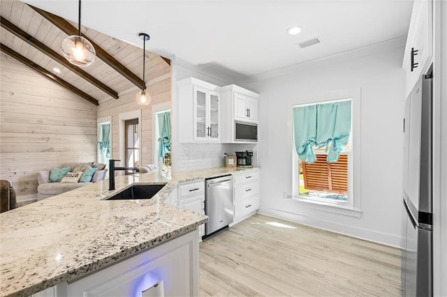 kitchen featuring lofted ceiling with beams, stainless steel appliances, sink, hanging light fixtures, and white cabinetry