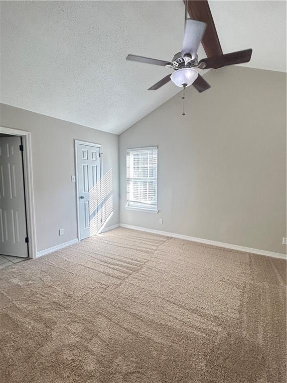 3120 Wellborne Dr W, Mobile, AL 36695 - empty room with lofted ceiling, light carpet, a ceiling fan, baseboards, and a textured ceiling