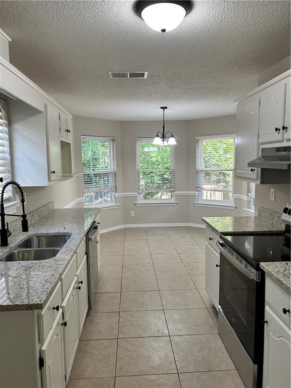 3120 Wellborne Dr W, Mobile, AL 36695 - kitchen featuring range with electric cooktop, a sink, under cabinet range hood, a textured ceiling, and white cabinets