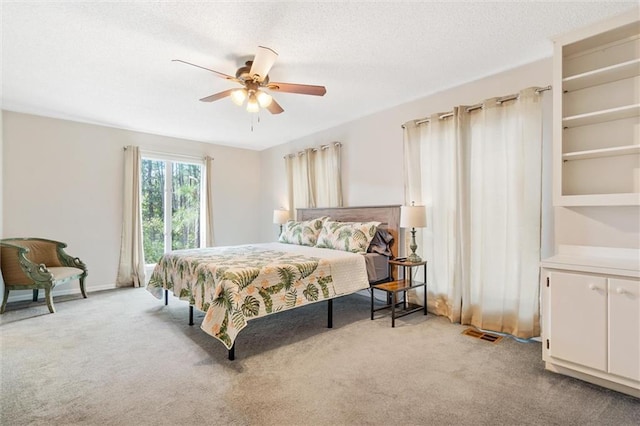 bedroom with visible vents, light carpet, ceiling fan, and a textured ceiling