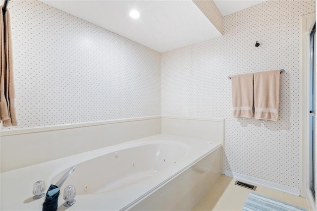 bathroom featuring a jetted tub, wallpapered walls, and visible vents