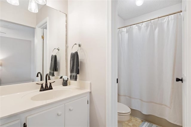 bathroom featuring toilet, a textured ceiling, and vanity