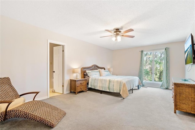 bedroom featuring light carpet, ceiling fan, baseboards, and a textured ceiling